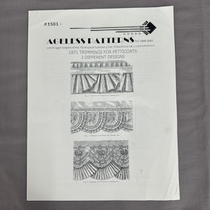 May include: A white paper with the text "AGELESS PATTERNS" and illustrations of vintage petticoat trimmings. The paper includes the text "1871 TRIMMINGS FOR PETTICOATS" and "3 DIFFERENT DESIGNS".
