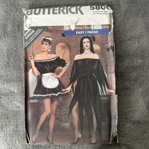 Puede incluir: Un patrón de costura vintage para dos disfraces: un disfraz de criada blanco y negro y un disfraz de vampiro negro. El patrón es de Butterick y está etiquetado como "Fácil/Facile".