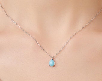 Puede incluir: Un collar de cadena de plata con un colgante turquesa en forma de lágrima.