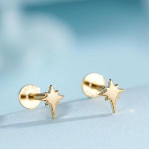 Op de afbeelding: Een paar gouden stervormige oorbel studs. De oorbellen zijn klein en delicaat, en ze hebben een eenvoudig, elegant ontwerp.