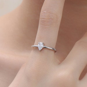 Puede incluir: Un anillo de plata con una piedra preciosa transparente en forma de pera.
