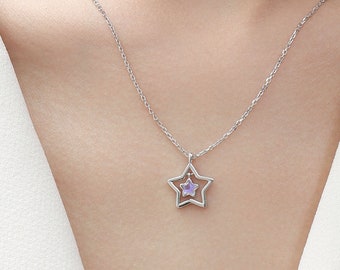 May include: A silver chain necklace with a star-shaped pendant. The star has a smaller star inside it, with a purple gemstone in the center.