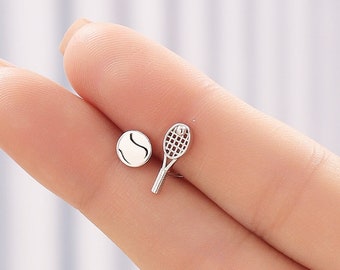 May include: A pair of silver tennis-themed earrings. One earring features a tennis racket and the other earring features a tennis ball.