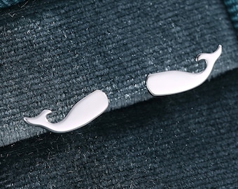 May include: A pair of silver whale-shaped earrings in a teal velvet jewelry box.