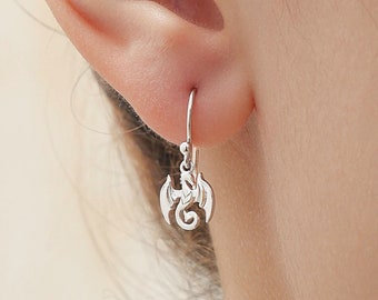 May include: Silver dangle earrings featuring a small dragon design.