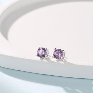 Puede incluir: Un par de pendientes de plata con piedras redondas de amatista púrpura.