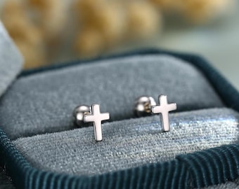 May include: A pair of silver cross stud earrings in a blue velvet jewelry box.
