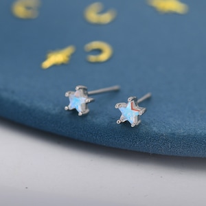 May include: A pair of silver star-shaped earrings with iridescent blue stones.