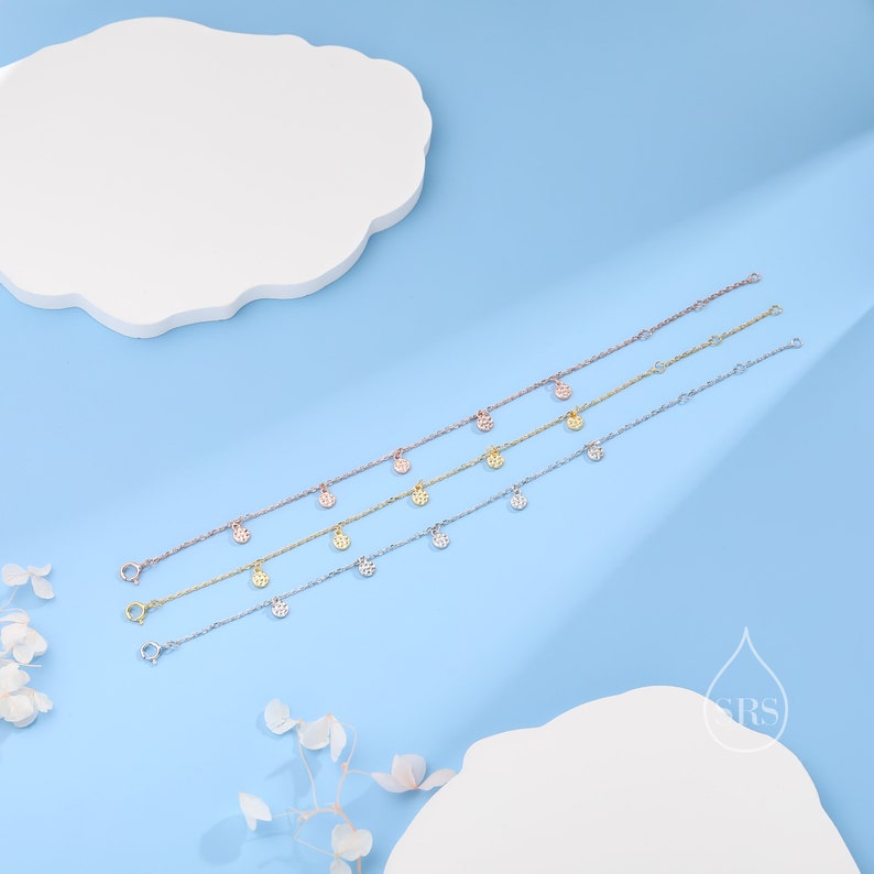 Puede incluir: Cuatro delicados brazaletes de oro, plata y oro rosa con peque&ntilde;os colgantes redondos engastados con pav&eacute;. Los colgantes cuelgan de la cadena y est&aacute;n espaciados uniformemente.