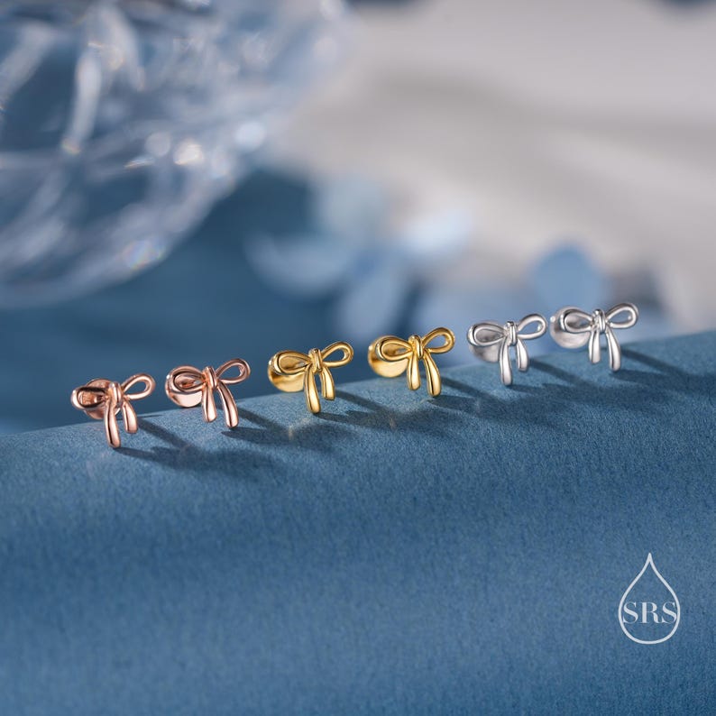 Puede incluir: Seis pares de peque&ntilde;os pendientes en forma de lazo en oro, oro rosa y plata.