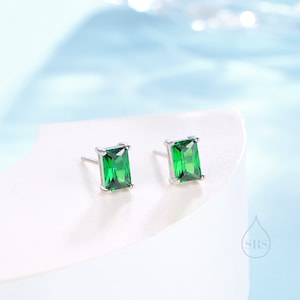 Peut inclure: Une paire de boucles d'oreilles en argent avec des pierres précieuses carrées de couleur vert émeraude.