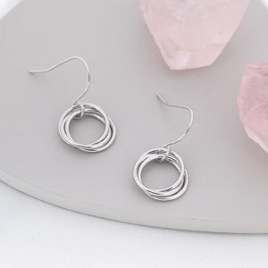 Brincos pendentes com anéis entrelaçados em prata de lei, também disponíveis com acabamento em ouro ou ouro rosa, brincos minimalistas com nó.