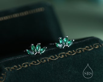 May include: A pair of silver earrings with green gemstone accents. The earrings are shaped like a flower with five petals.