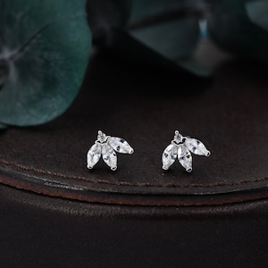 Può includere: Un paio di orecchini d'argento con un delicato design a foglia decorato con pietre di zircone cubico trasparenti.