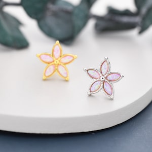 May include: Two flower-shaped earrings with pink opal stones. The earrings are made of gold and silver.