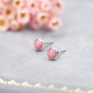 Peut inclure: Une paire de boucles d'oreilles en argent avec des pierres rondes roses.