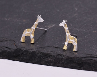 May include: A pair of silver and gold giraffe stud earrings. The giraffes are detailed with a textured pattern.