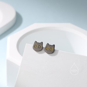 Peut inclure: Une paire de boucles d'oreilles clous en forme de chat noir avec des accents dor&eacute;s. Les boucles d'oreilles sont petites et d&eacute;licates, et elles seraient un excellent cadeau pour tout amateur de chats.