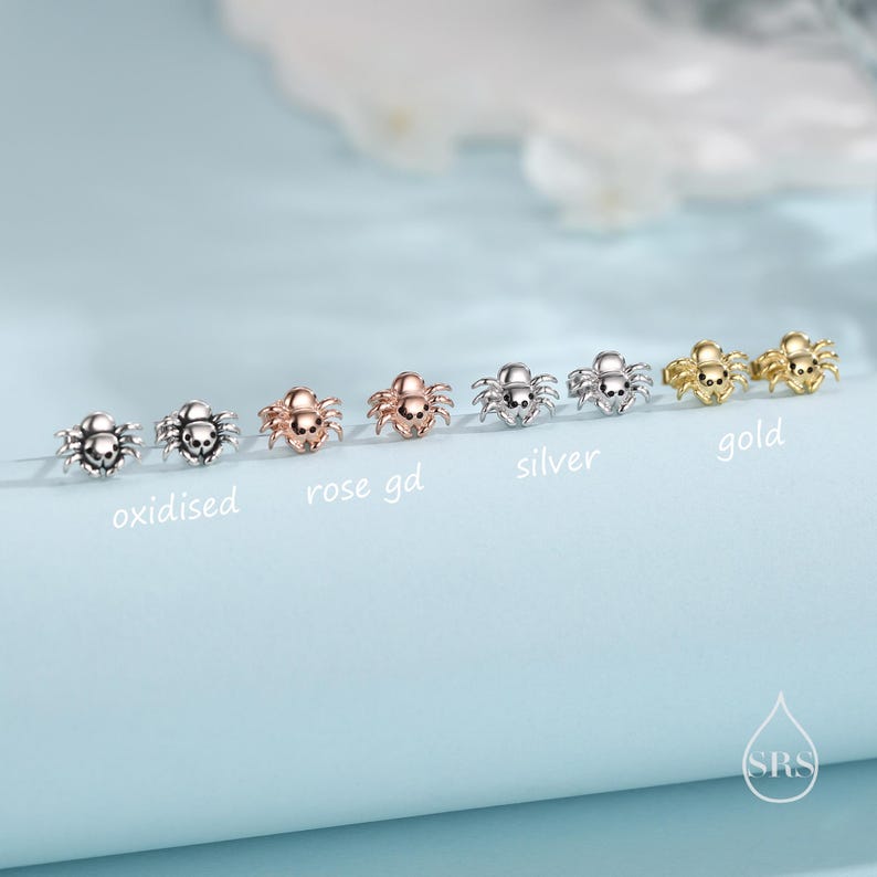 May include: Five pairs of spider earrings in different finishes: oxidized, rose gold, silver, and gold. The earrings are small and delicate, perfect for adding a touch of whimsy to any outfit.