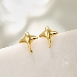May include: A pair of gold-toned earrings shaped like stingrays. The earrings are small and delicate, and they would make a great gift for someone who loves the ocean.
