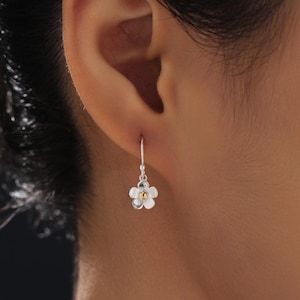 Pequeños pendientes de gancho con forma de flor de nomeolvides en plata de ley con detalles en oro, aros con flores y margaritas.