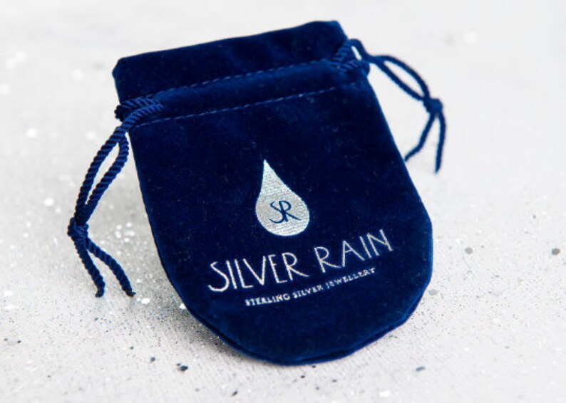 May include: A blue velvet pouch with a silver rain drop logo and the text "Silver Rain Sterling Silver Jewellery".