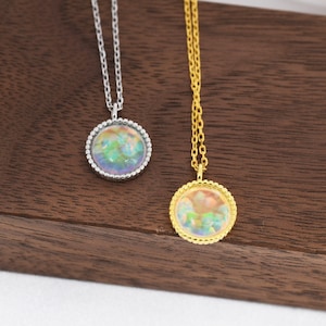 May include: Two necklaces with iridescent round pendants. The pendant on the left necklace is silver and the pendant on the right necklace is gold.