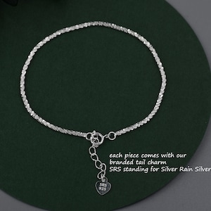 Puede incluir: Un brazalete de cadena de plata con un dije en forma de coraz&oacute;n que dice "SRS 925". El dije est&aacute; unido al brazalete con una cadena peque&ntilde;a. Cada pieza viene con nuestro dije de cola de marca. SRS significa Silver Rain Silver.