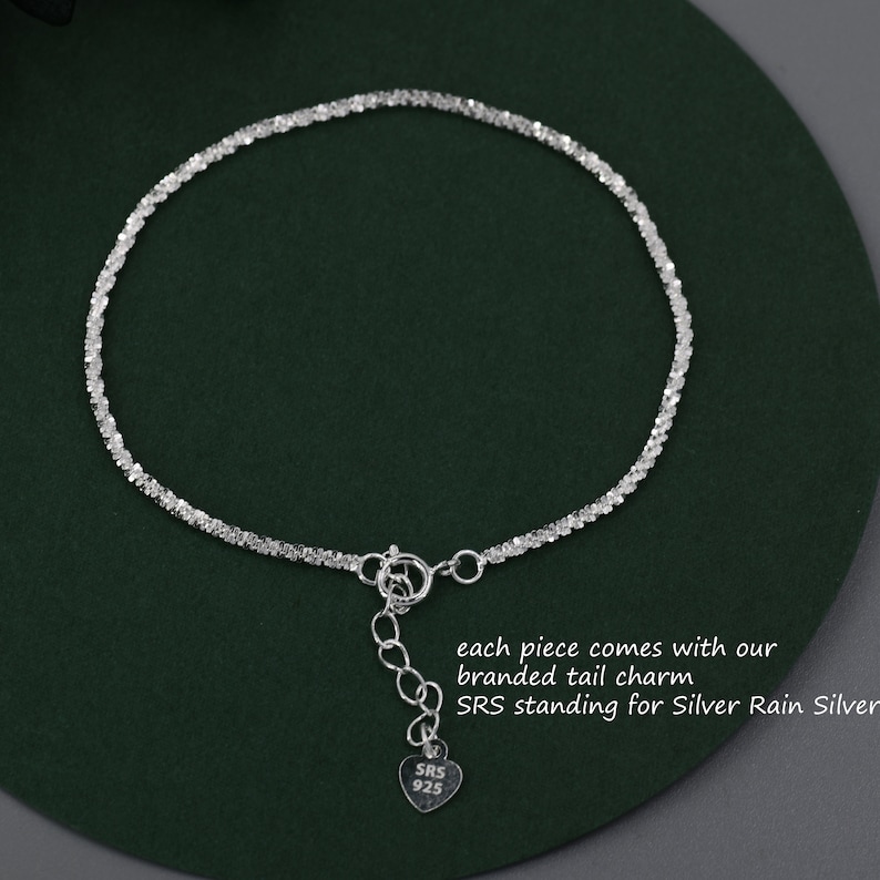 Puede incluir: Un brazalete de cadena de plata con un dije en forma de coraz&oacute;n que dice "SRS 925". El dije est&aacute; unido al brazalete con una cadena peque&ntilde;a. Cada pieza viene con nuestro dije de cola de marca. SRS significa Silver Rain Silver.