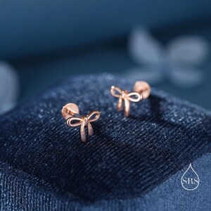 Puede incluir: Un par de pendientes en forma de lazo de oro rosa. Los pendientes son peque&ntilde;os y delicados, y ser&iacute;an un gran regalo para una ocasi&oacute;n especial.