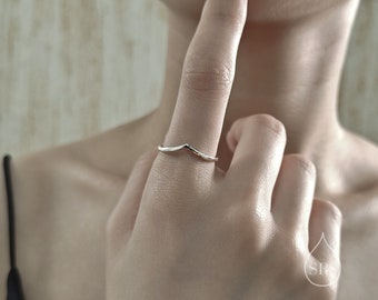 Peut inclure: Une fine bague en argent poli présentant un design en forme de V ou de chevron. L'anneau possède une finition métallique lisse avec une pointe centrale. Un petit logo circulaire contenant les lettres SRS dans une goutte est visible au coin.