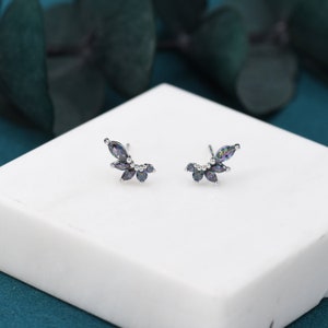 Può includere: Un paio di orecchini d'argento con un design curvo adornato con più pietre preziose nere iridescenti.