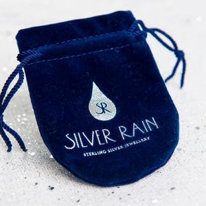 Peut inclure: Pochette &agrave; bijoux en velours bleu marine avec cordon de serrage. Le sac porte l'inscription "SILVER RAIN STERLING SILVER JEWELLERY" en blanc et un logo goutte de pluie argent&eacute;.