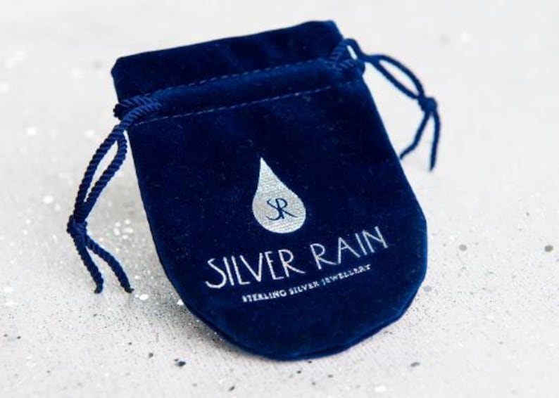 Peut inclure: Pochette &agrave; bijoux en velours bleu marine avec cordon de serrage. Le sac porte l'inscription "SILVER RAIN STERLING SILVER JEWELLERY" en blanc et un logo goutte de pluie argent&eacute;.