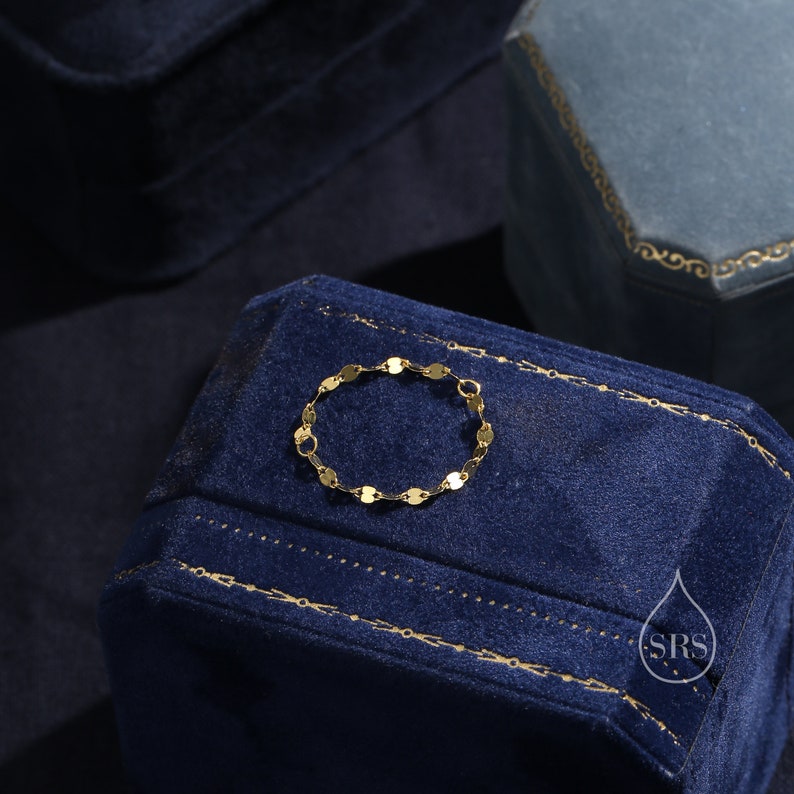 May include: A gold chain bracelet with small, oval-shaped links. The bracelet is displayed on a blue velvet box.