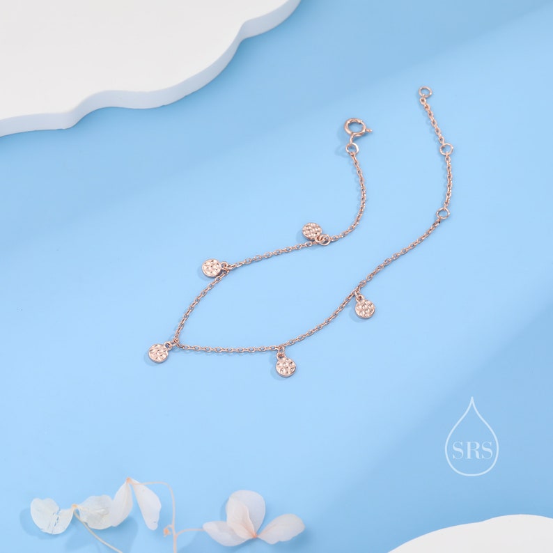 Puede incluir: Un delicado brazalete de cadena de oro rosa con cinco peque&ntilde;os abalorios redondos texturizados. Los abalorios est&aacute;n espaciados uniformemente a lo largo de la cadena.