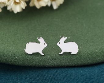 May include: A pair of silver rabbit stud earrings. The rabbits are facing opposite directions and have a simple, minimalist design.
