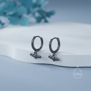 May include: A pair of black hoop earrings with a small bat charm hanging from each hoop.