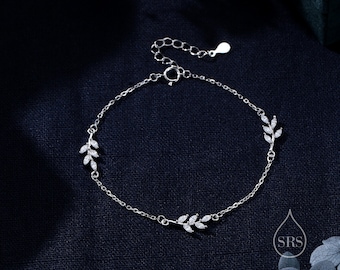 May include: A silver bracelet with a delicate chain and three leaf-shaped charms adorned with small clear stones.