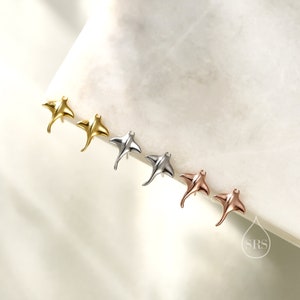 May include: Four pairs of sterling silver earrings in the shape of a manta ray. The earrings are shown in gold, silver, rose gold, and a darker silver finish.