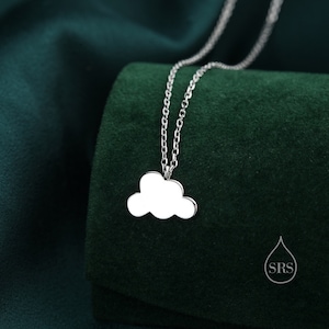 May include: A silver chain necklace with a cloud-shaped pendant. The pendant is a simple, flat design with a smooth surface.