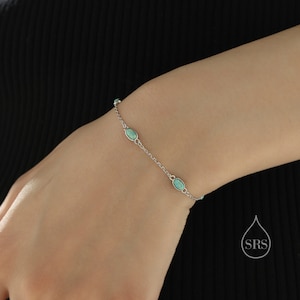 Könnte beinhalten: Ein silbernes Kettenarmband mit türkisfarbenen ovalen Steinen.