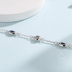 Peut inclure: Un bracelet en cha&icirc;ne argent avec trois pierres bleues de forme ovale et une seule pierre ronde au centre.