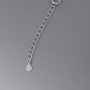 May include: A silver chain with a small silver tag that says "925 S925".