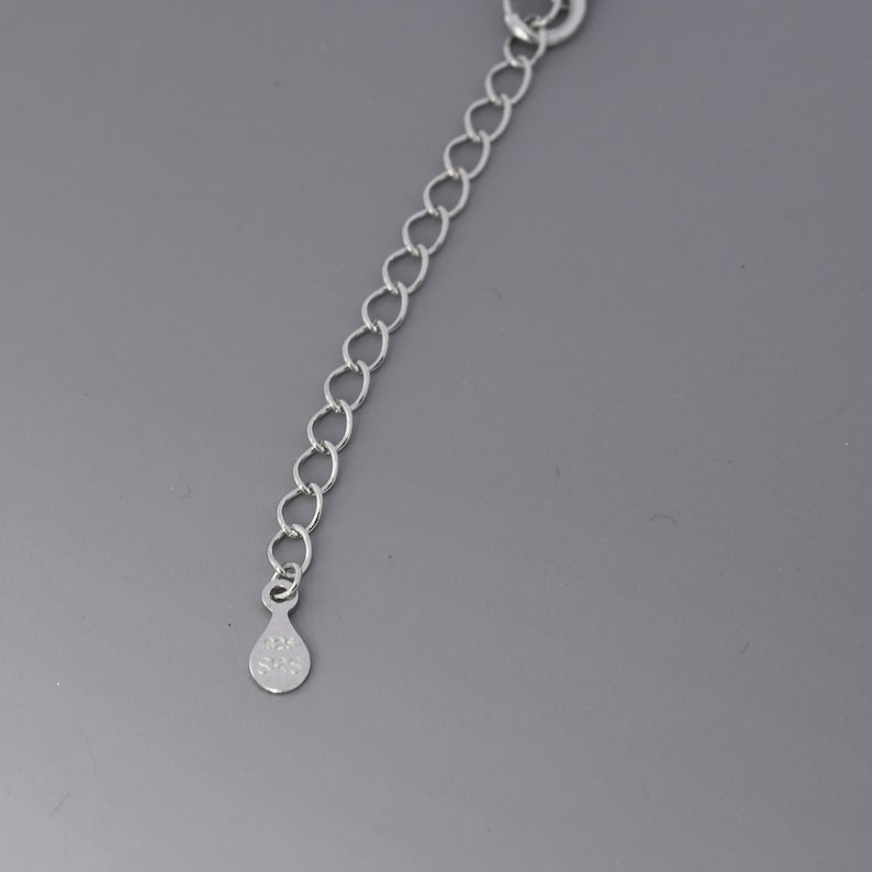 May include: A silver chain with a small silver tag that says "925 S925".