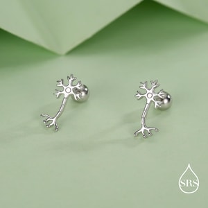 May include: A pair of silver-colored neuron stud earrings. Each earring features a detailed neuron design with a round post for secure wear. The earrings are displayed against a soft green background.