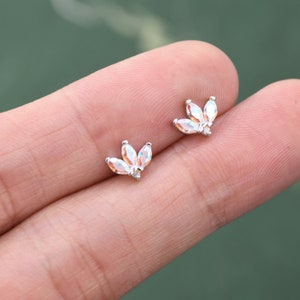 Può includere: Un paio di orecchini d'argento con accenti di cristallo iridescente a forma di fiore.