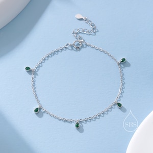 Pode incluir: Um bracelete de corrente de prata com cinco pedras verdes penduradas em forma de lágrima.