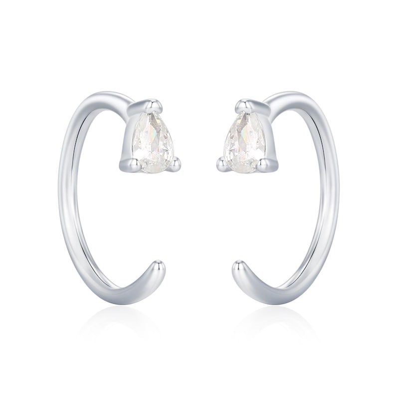 Peut inclure: Une paire de boucles d'oreilles cr&eacute;oles argent&eacute;es. Chaque boucle d'oreille est orn&eacute;e d'une pierre pr&eacute;cieuse claire en forme de poire en haut. Les cr&eacute;oles sont incurv&eacute;es, avec une finition lisse et polie. Fond blanc.