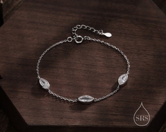 May include: A silver bracelet with three marquise-shaped clear stones. The bracelet has a delicate chain and a lobster clasp.
